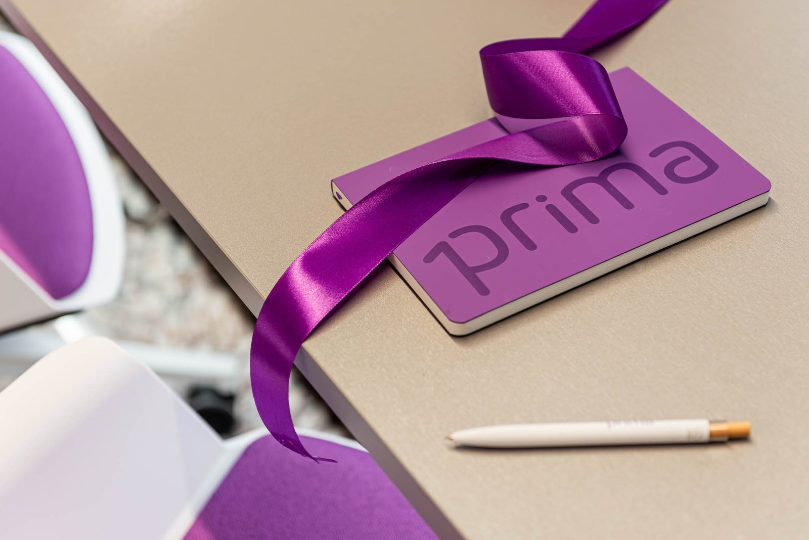 Agenda Prima Assicurazioni viola con nastro di inaugurazione e penna brand - dettaglio rebranding Partner Ufficiale Comunale Srl
